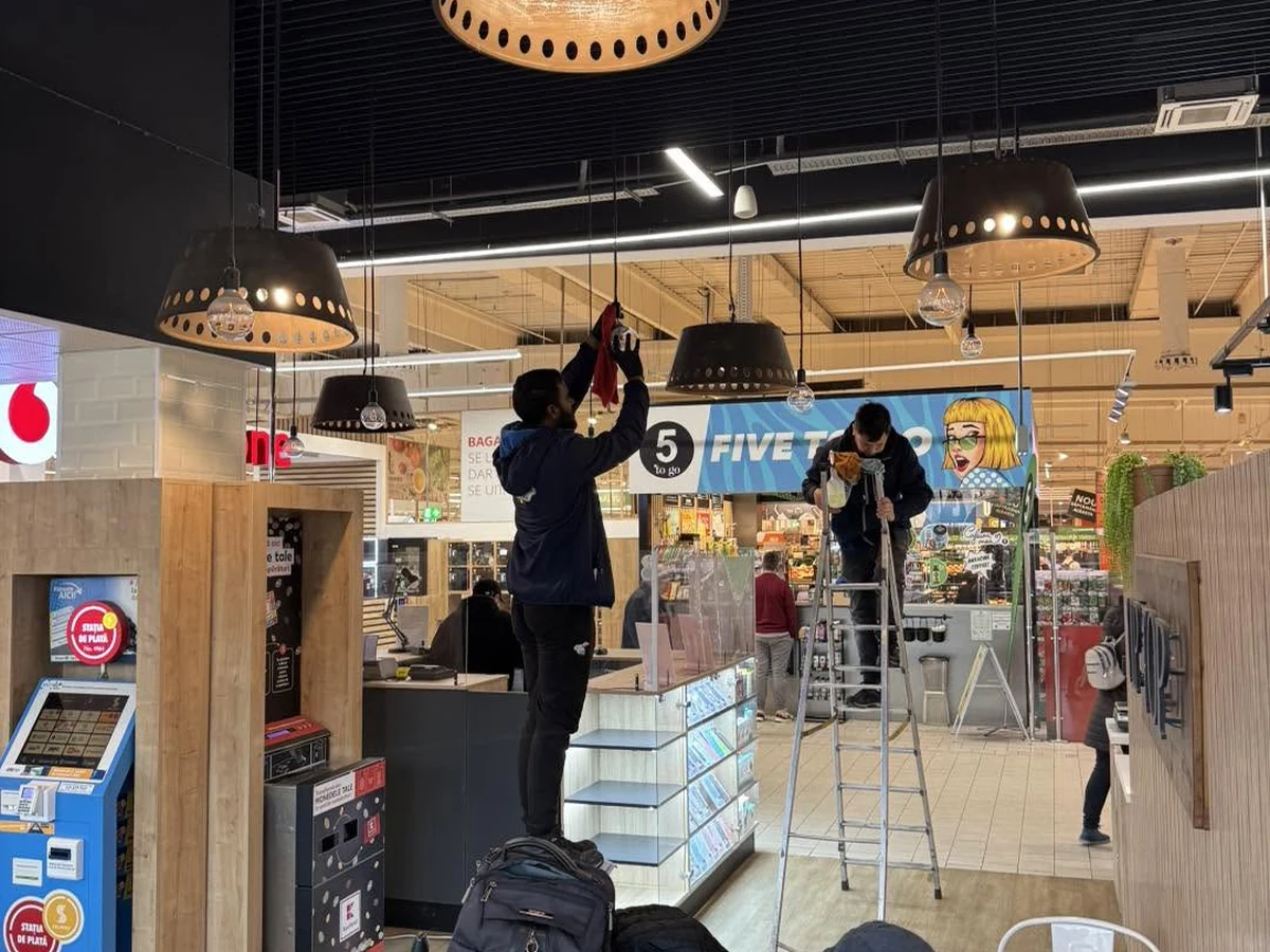 Echipă Best Clean curățând suprafețe vitrate într-un spațiu comercial